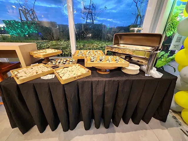 Catering buffet table with trays of pastries and a chafing dish