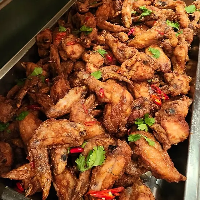 Chafing dish full of spicy fried chicken wings