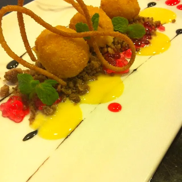 Cheesecake poppers plated with fruit sauces