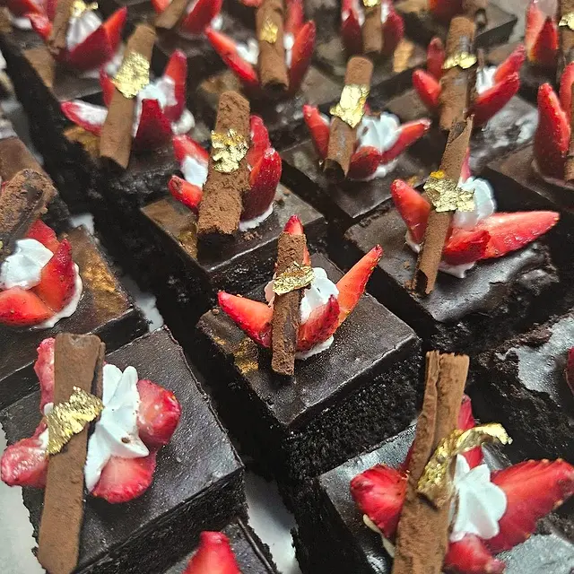 Chocolate cake slices topped with strawberries and chocolate shards